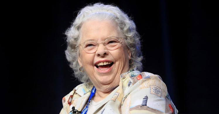 Joanne Rogers smiles in front of a black background