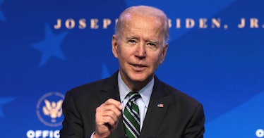 President Joe Biden speaks in front of blue background