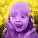 pink tint edit of a girl surrounded by yellow flowers laughing at spring jokes for kids