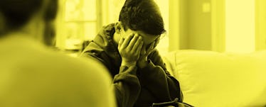 A kid sitting on a sofa opposite his parent, his hands on his face because he made a mistake, waitin...