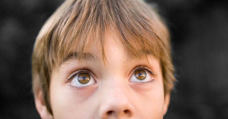 close up shot of a kid looking up as he ponders the answer to a would you rather question