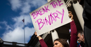 A protestor holds a sign that says "Break the Binary"