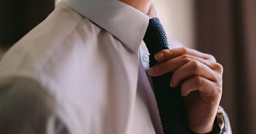 A man adjusts his tie: illustrates readiness to dates after divorce