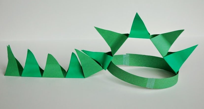 green construction paper spiked dinosaur hat on a white background