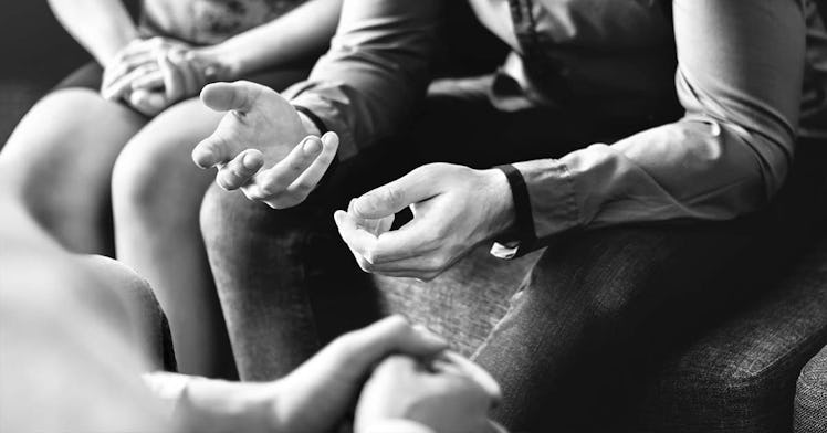 black and white photo of couple speaking to third party