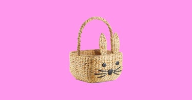 wicker Easter basket for kids with a embroidered bunny face isolated on pink background