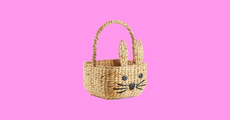 wicker Easter basket for kids with a embroidered bunny face isolated on pink background