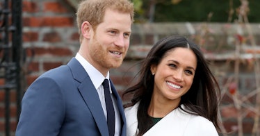 Meghan and Harry smile at a camera