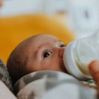 baby boy with mother drinking from bottle