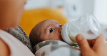 baby boy with mother drinking from bottle