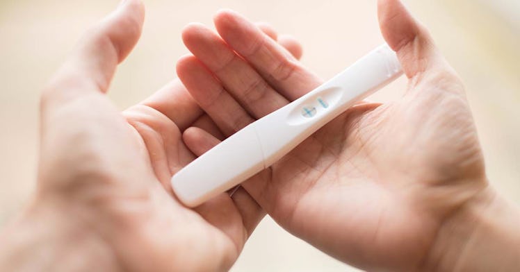 Close up of hands holding a pregnancy test.