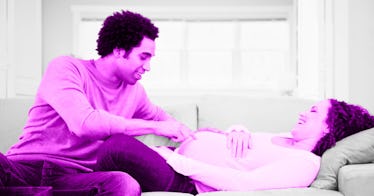 A father touching and talking to his pregnant wife's belly
