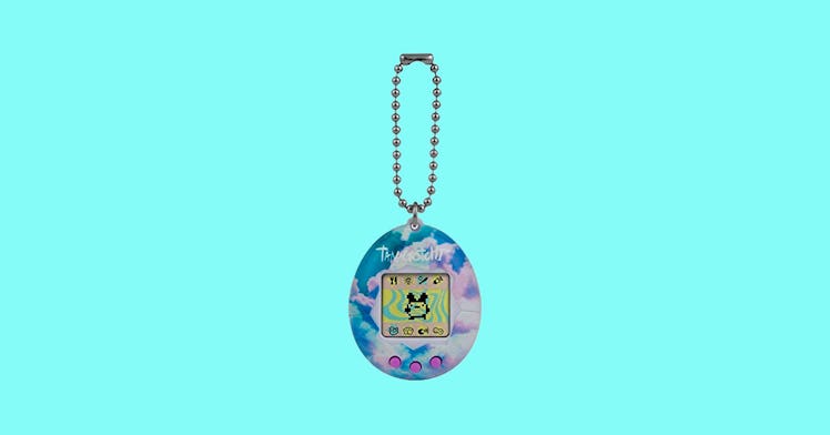 A Tamagotchi, one of the best '90s toys, set against an aqua background