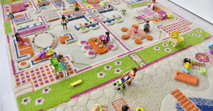 Close-up of a mulitcolored 3-D rug with figures arranged on the play carpet the way a child might