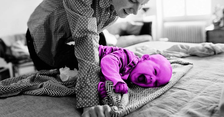 smiling baby with mother rolling over on a mat