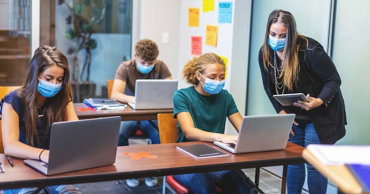 Masked students sit in a classroom