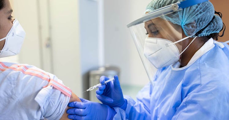 A health care worker vaccinates a person