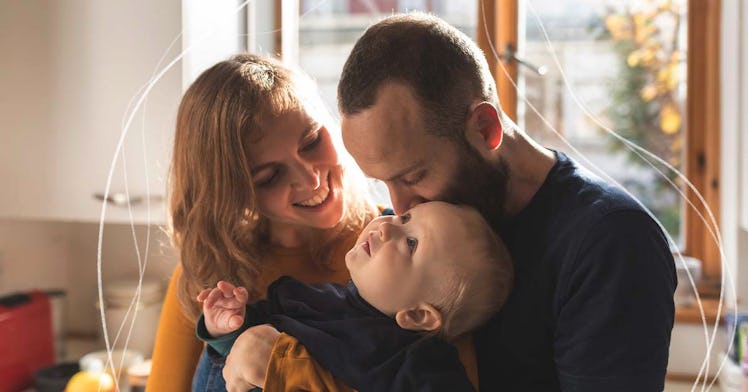 man and wife lovingly staring down at the baby they're holding