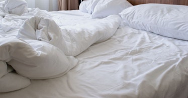 image of white rumpled hotel sheet on bed