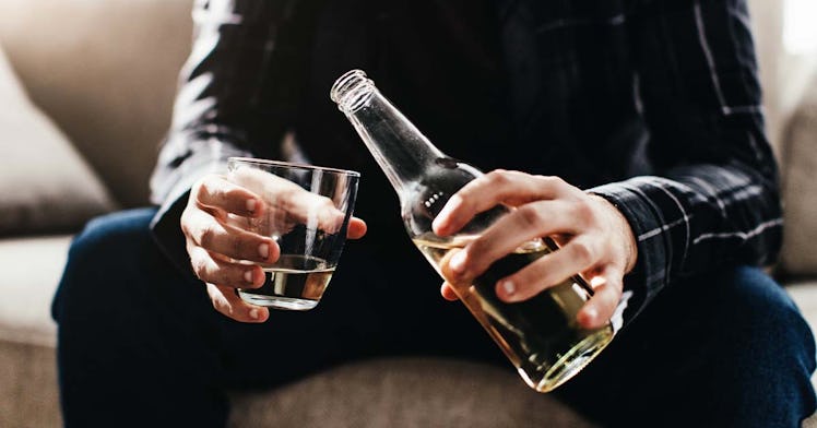 A human man holds a beer bottle and a glass