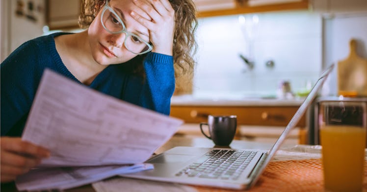 A person frowns while looking at their tax forms
