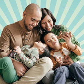 An Asian family smiling and cuddling together against a blue starburst background
