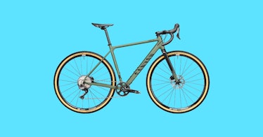 a charcoal-gray gravel bike against a bright blue background