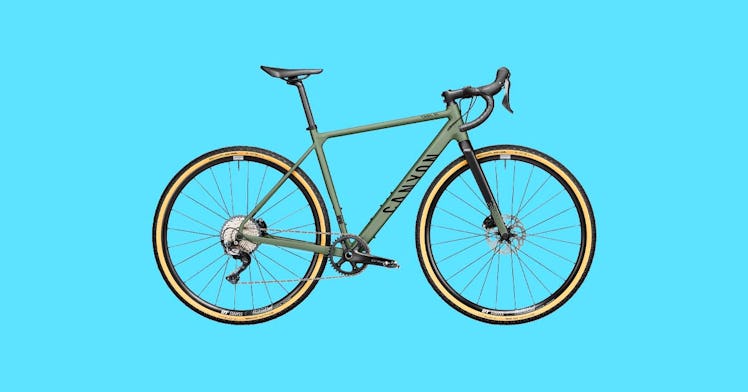 a charcoal-gray gravel bike against a bright blue background