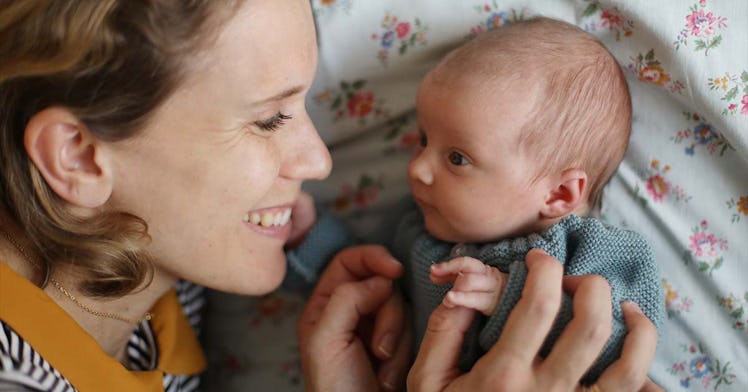 A mom and her infant baby smile at one another