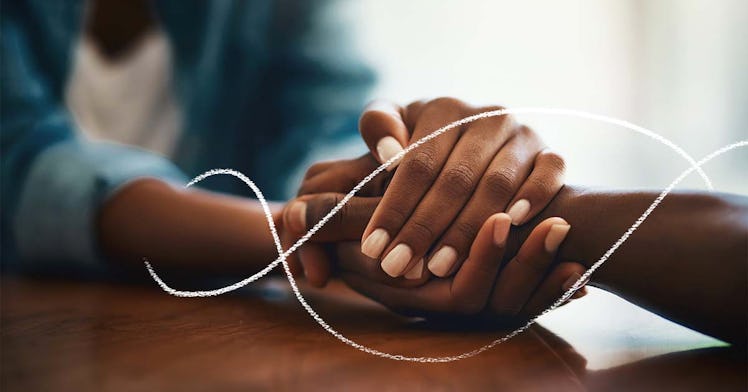 couple holding hands across a table in a comforting way
