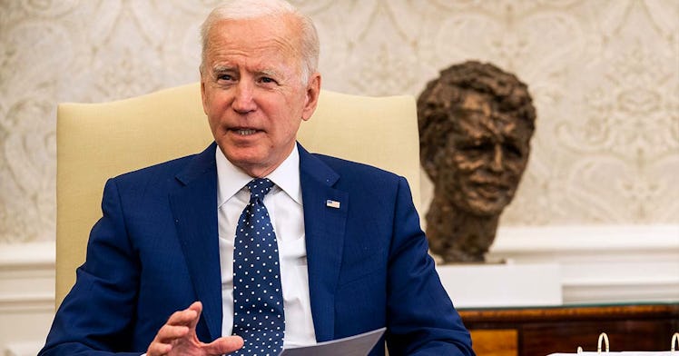 Biden speaks in the oval office with a bust of JFK behind him