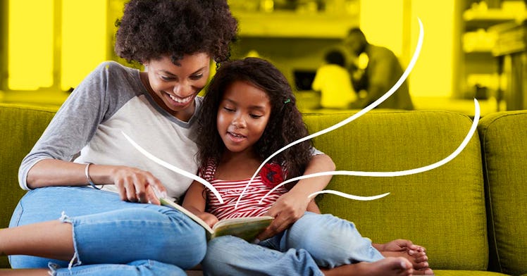 A mother and child reading a book on a couch