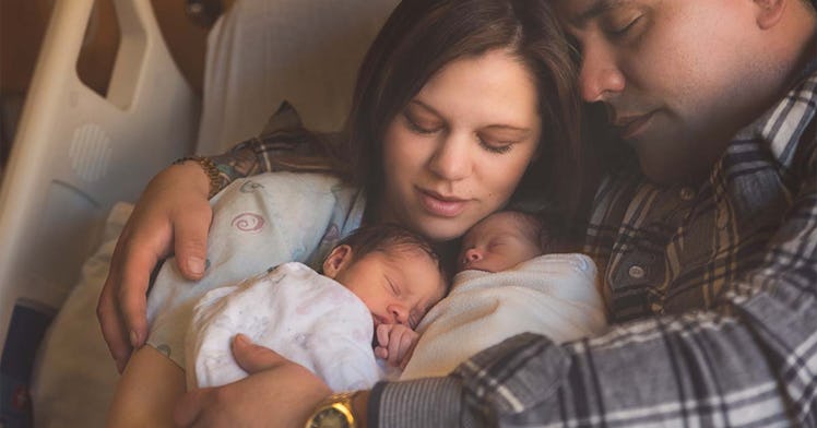 Two parents hold their infant baby