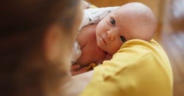 An infant looks at their mom