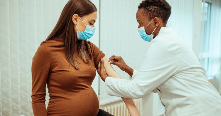 A pregnant person is being treated by a doctor