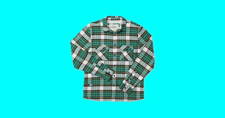 a green plaid men's shacket is pictured against a sky blue backdrop