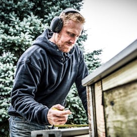 Father wearing 3M Worktunes hearing protection works in his backyard