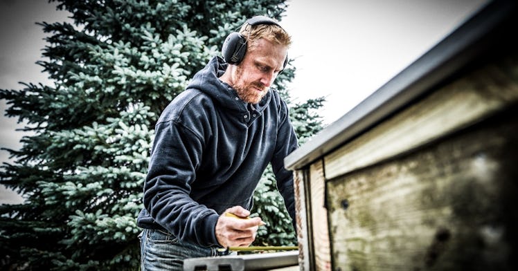 Father wearing 3M Worktunes hearing protection works in his backyard