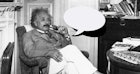 爱因斯坦在办公室里抽着烟斗的黑白照片，旁边是一个空的演讲气泡代表……