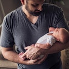 A man holding an infant in his arms, depicting the most popular baby names of 2020