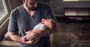 A man holding an infant in his arms, depicting the most popular baby names of 2020