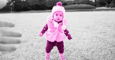 A child developing the ability to walk stands in a field looking worried