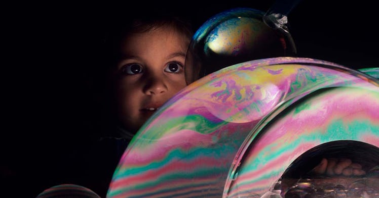 Girl with giant bubble in kids museum