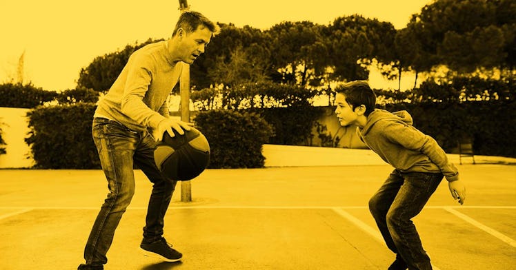 A father and a son playing basketball on a basketball court