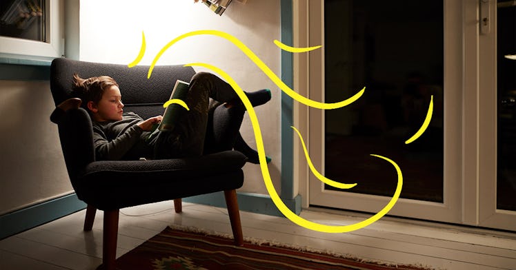 a girl sits curled up in a sofa chair reading a book with illustrated wind flowing between her and t...