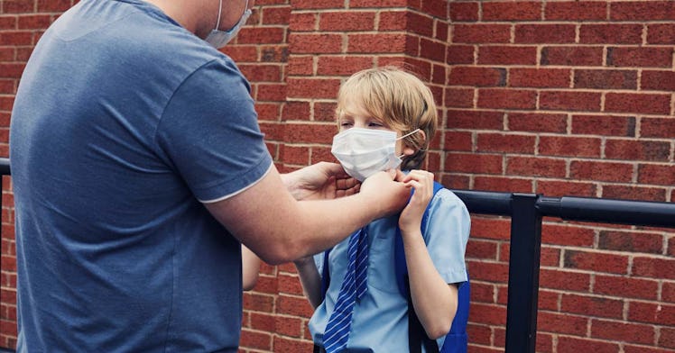 An adult secures a mask on a child