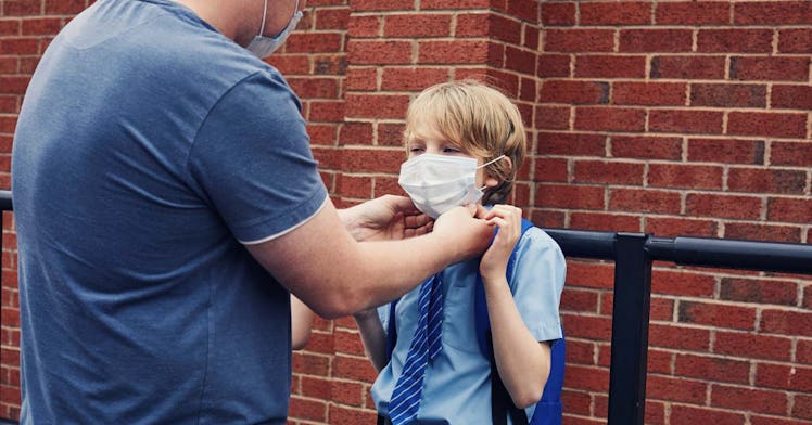 An adult secures a mask on a child