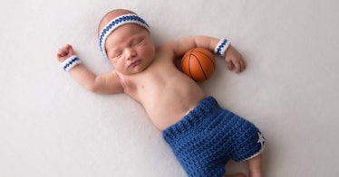 A baby holds a basketball