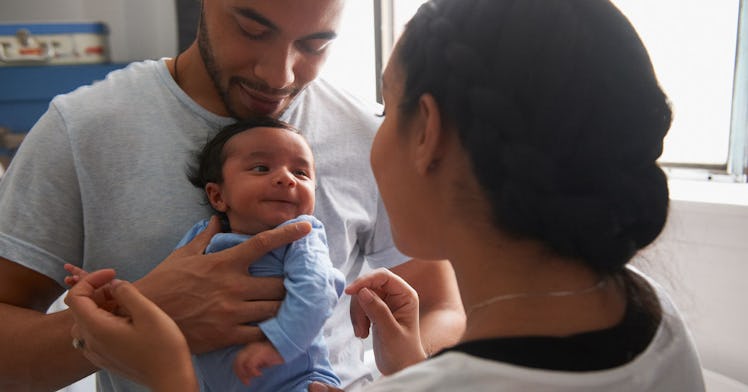 A baby is held by their dad