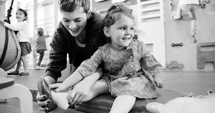 A teacher and a kid sit together, in black and white